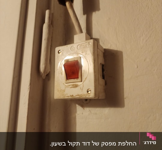 מתג חשמלי על קיר עם חוטים חשופים